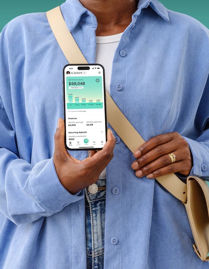 Woman showing Bonsai personal finance app on phone with active home-buying goal plan