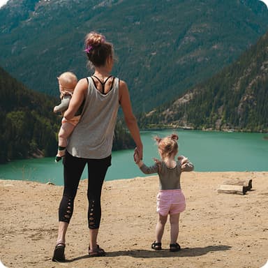 Woman holding two babies (one on ground, one carried) – family security via future planning in Bonsai AI financial planning