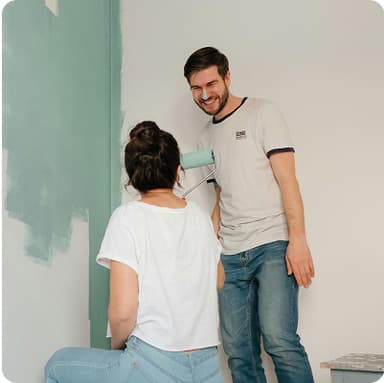 Couple painting their home, husband with paint on nose – celebrating homeownership goals in Bonsai personal finance app